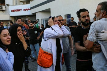 A Palestinian medic, center, and others cry after learning about the death of a relative at the al-Shifa hospital, following Israeli airstrikes on Gaza City, on Tuesday.