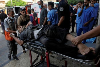 A Palestinian wounded in Israeli bombardment is brought to a hospital in Deir el-Balah, on Tuesday.