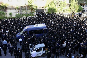 Friends and family gather around a hearse to mourn rabbinical judge, Elimelech Wasserman, who was killed in a shooting attack when Hamas gunmen opened fire at a bus stop at the entrance to Jerusalem, ahead of his funeral in Jerusalem on Thursday.
