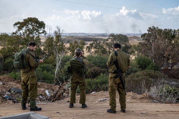 Israeli troops look on at the Gaza destruction