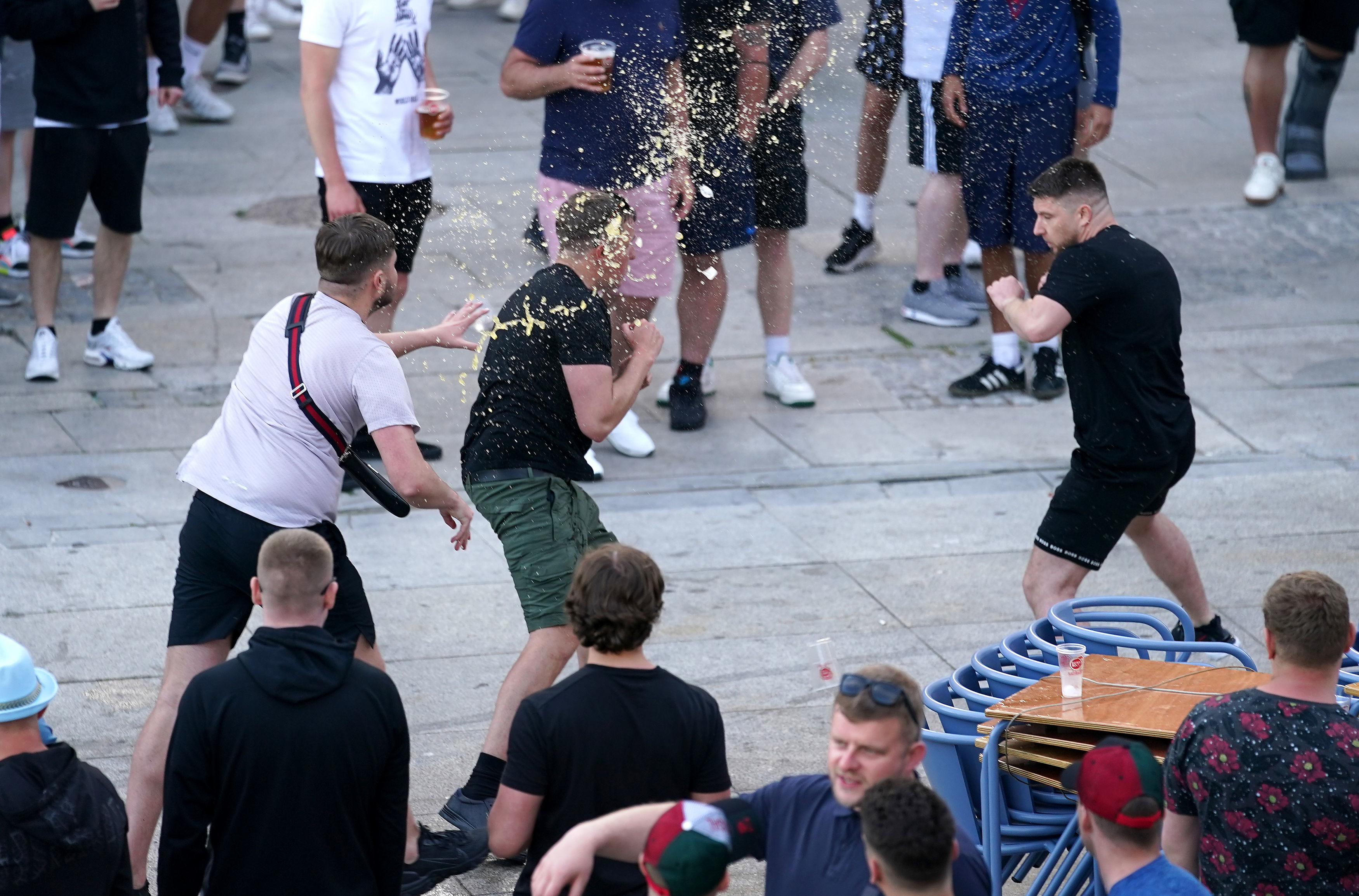 One lad throws beer on another fan as he squares off in the city