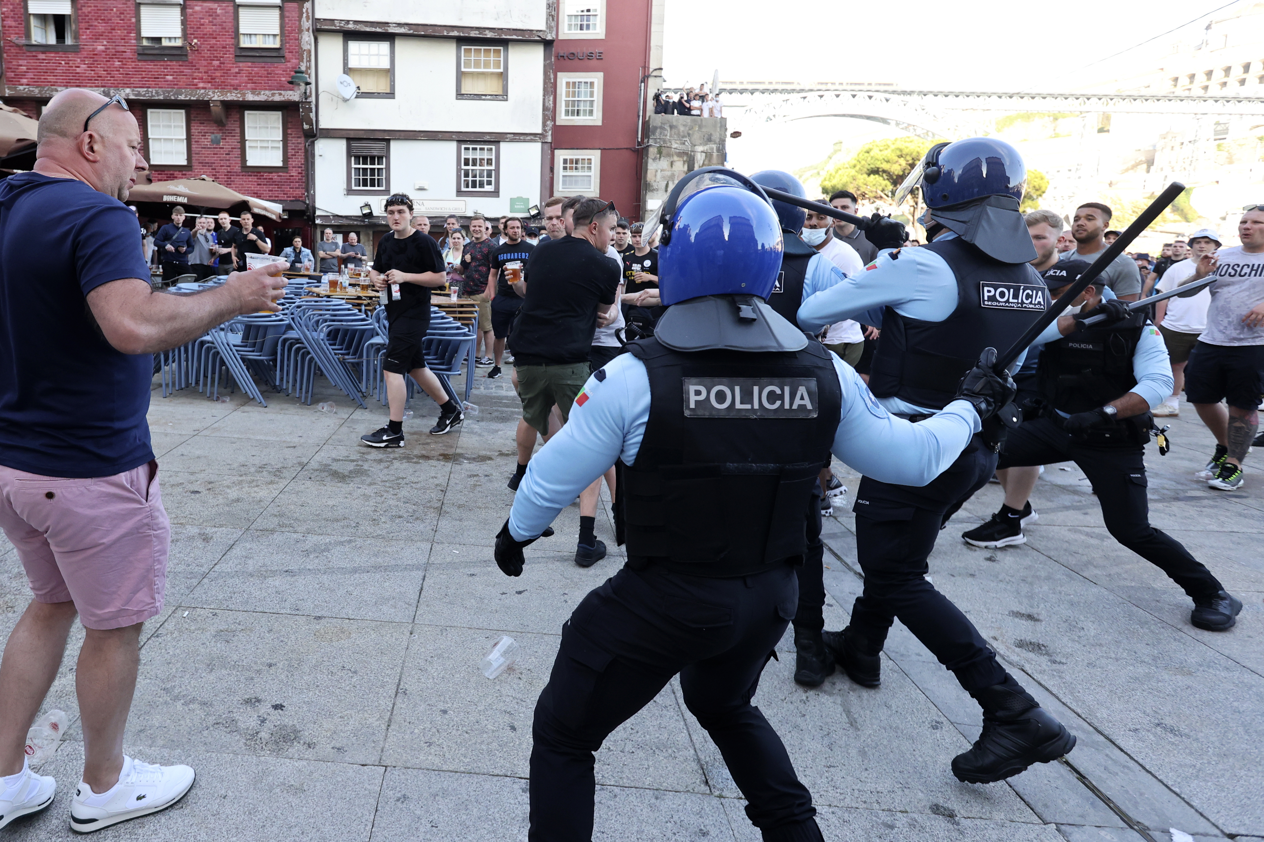 Riot cops with batons break up fights between the two fans